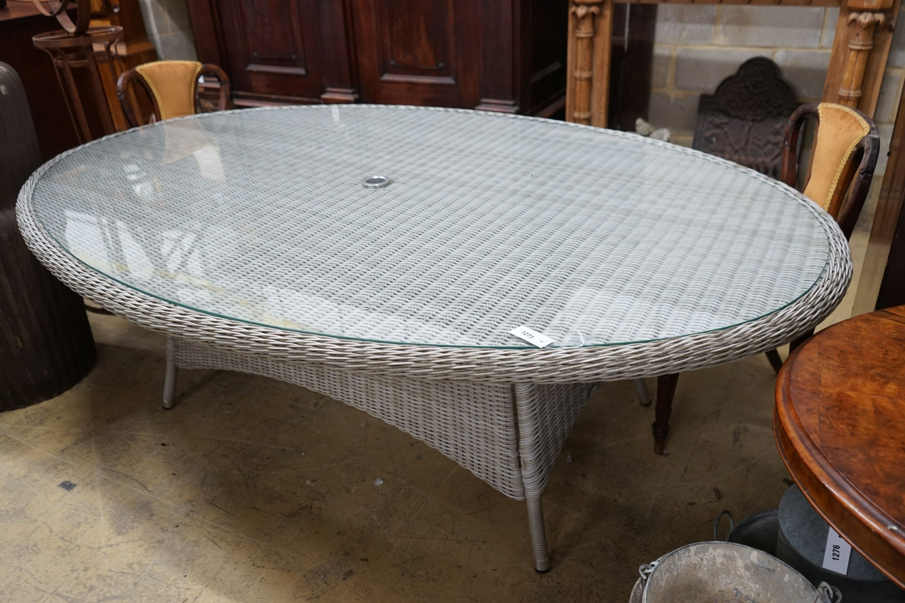 A Bramblecrest oval all weather rattan glass topped garden table, length 220cm, depth 144cm, height 73cm